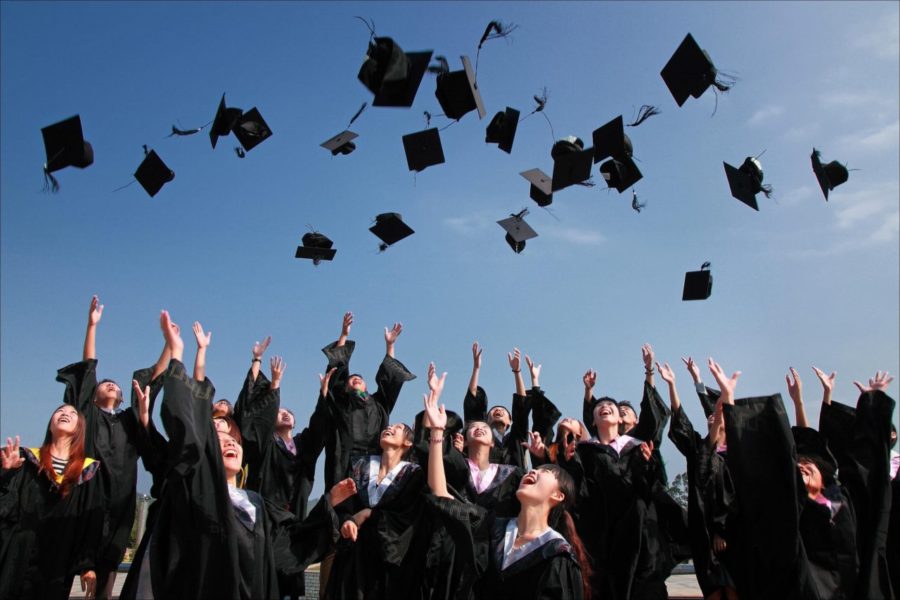 大学の卒業式で角帽を空に投げる卒業生達
